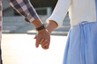 © New Africa - Couple holding hands together outdoors on summer day, closeup
