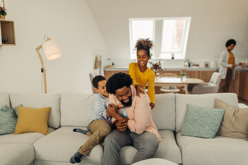 Wall Mural - Afro children is having fun with their father in the cozy of their living room