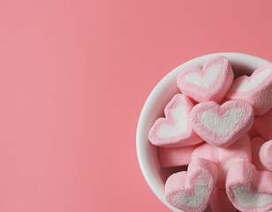  flat lay of hearts shape marshmallows in white cup  on pink background,