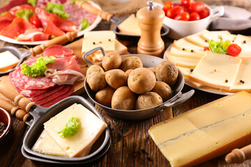 Wall Mural - traditional raclette cheese party on wood background