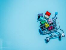 Colorful Threads On Mini Supermarket Trolley. Shopping Online Concept