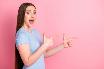 Poster - Photo portrait profile of screaming girl pointing two fingers to side isolated on pastel pink colored background