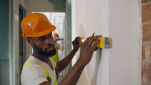African Male Worker Checking Level Of The Wall With The Bubble Level Tool