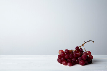 still life of red grapes on white wooden table