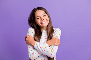 Photo portrait of girl hugging herself isolated on vivid violet colored background