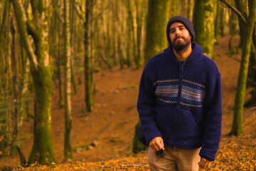 Wall Mural - Lifestyle, a young man in a blue wool sweater and a hat enjoying the forest in autumn. Artikutza Forest in San Sebastián, Gipuzkoa, Basque Country. Spain