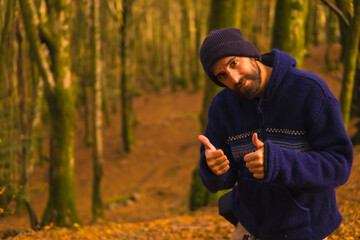 Wall Mural - Lifestyle, a young man in a blue wool sweater and a hat enjoying the forest in autumn. Artikutza Forest in San Sebastián, Gipuzkoa, Basque Country. Spain