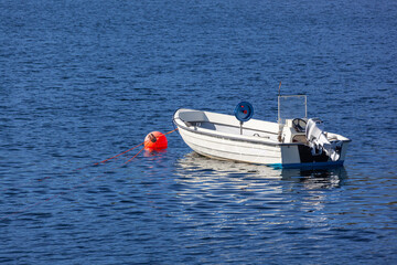 Wall Mural - White boat on an anchor on quiet surface of the water of the Barents sea, Northern Norway