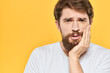 © SHOTPRIME STUDIO - Man in white t-shirt emotions studio gestures with hands displeased facial expression yellow background