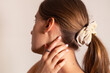 © Jan - Blond woman with her hand touching her neck, rose ring on her finger. Side view.