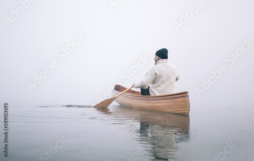 Cuadros en Lienzo Rear view of man paddling canoe in the winter, copy space