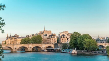 Wall Mural - Sunset timelapse over Seine river, Pont Neuf bridge and Cite island with Royal palace, Conciergerie and medieval buildings. Evening Paris cityscape panoramic view. Paris, France