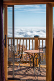Fototapeta Boho - Balcony terrace outside in Wintergreen, Virginia with blue ridge mountain view and cloud inversion with blue sky and sunlight on chairs table railing