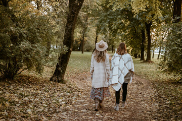 Two ladies walking in the park from behind