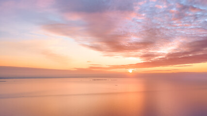 Wall Mural - Calm amber colored sea and sky at sunset