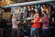 © luckybusiness - people socializing in front of truck food, drinking juices, talking