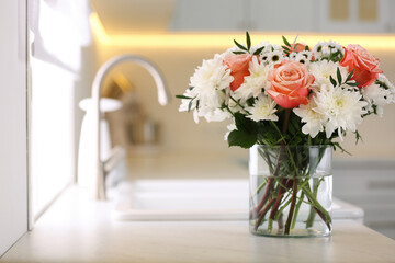 Canvas Print - Vase with beautiful flowers on countertop in kitchen, space for text. Interior design