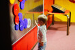 © natalialeb - Toddler child plays with magnetic gears in the children's science amusement park, the child plays independently in the children's center,