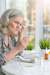 Portrait of sick senior woman with pills