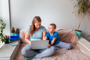 Wall Mural - Mother with kid working from home during quarantine. Stay at home, work from home concept during coronavirus pandemic