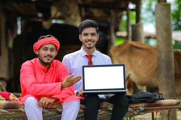 Wall Mural - Young indian farmer and agronomist showing laptop screen at home