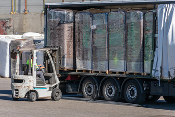 Wall Mural - Wheelbarrow loading a peat pallet onto a truck.