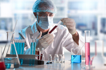 scientist in laboratory looking at a sample in test tube