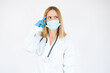 © Danko - Beautiful female doctor or nurse wearing protective mask and latex or rubber gloves on white background with copy space. Health care concept