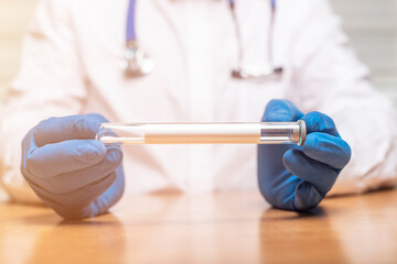 Male doctor hands holding test tube in laboratory close up