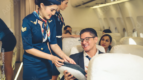 Cabin crew give service to passenger in airplane . Airline transportation and tourism concept.