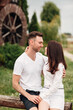 © Andriy Medvediuk - Couple in love walks near a large wooden mill on summer day. man and woman are having fun outdoors.