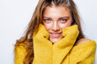 © Julia - Portrait of beautiful happy girl smile in yellow sweater and looks at the camera, hiding her hands in the sleeves of a yellow sweater clasping her face. smile. close-up.