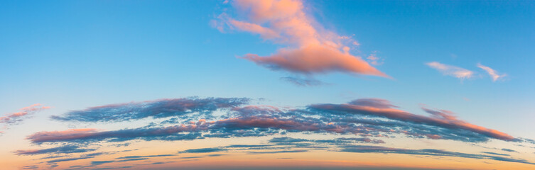 Wall Mural - vanilla sunset sky panoramic shot. pink golden blue evening sky with long stratus clouds over the ho