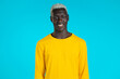 © kohanova1991 - Portrait of smiling african american handsome man in yellow looking to camera. Guy in studio on bright blue background.