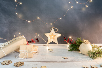 Christmas and zero waste, eco friendly packaging. wrapped gifts in craft paper with wooden snowflakes and star on a wooden table on a dark background. ecological Christmas holiday concept, eco decor