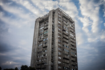 Selective blur on a High rise building from Novi Beograd, in Belgrade, Serbia, a traditional communist housing ensemble with a brutalist style, with a moving sky effect in background.