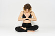 © SHOTPRIME STUDIO - Woman in leggings meditate in a light room with her legs crossed yoga asana