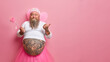 © wayhome.studio  - Funny bearded man fairy points thumb away on blank space has big tattooed belly holds magic wand invites you to childrens holiday isolated over rosy background. Dad dresses to entertain kids
