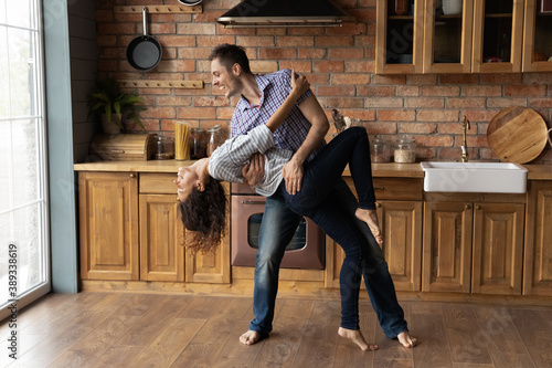 Cuadros en Lienzo Overjoyed Caucasian man and woman enjoy happy leisure weekend in new home dancing waltzing together