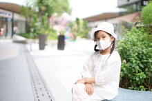 Asian Child Or Kid Girl Wearing White Dress Hat And N95 Face Mask To Close Mouth Nose With Flu Cough Sick For Protect Covid-19 Coronavirus Or PM2.5 Dust At Department Store Or Shopping Mall Travel