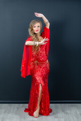 beautiful girl in a red ethnic dress dancing oriental dances