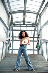 Wall Mural - young cute teenage african girl in industrial zone happy smiling having fun, big city lifestyle fashion people