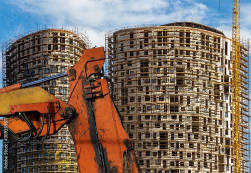 Cuadros en Lienzo Part of a construction machine (excavator or crane) with multi-storey building u