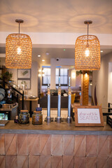 Wooden counter of a vegan restaurant with two handcrafted lamps hanging above it