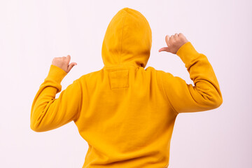 A beautiful young girl posing in a yellow sports sweatshirt