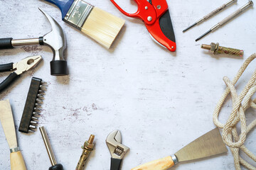 Top view of Set of construction and maintenance tooling for handyman on white concrete background with copy space