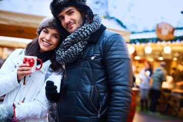 Wall Mural - Happy romantic couple enjoying christmas fair.