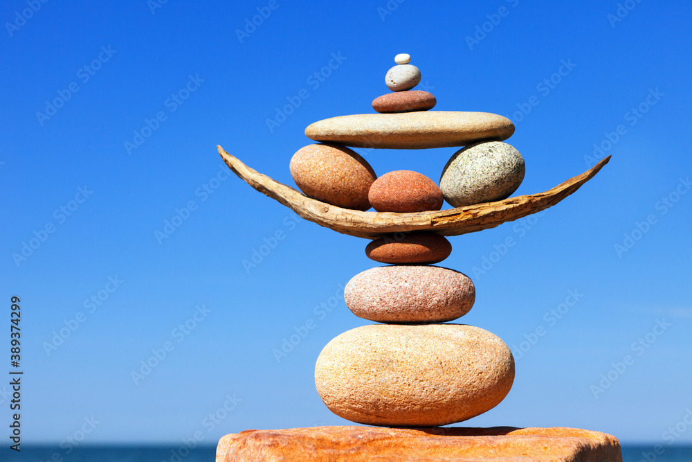 Rock zen pyramid of colorful pebbles on a beach on the background of ...