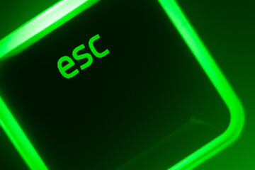 Green illuminated keyboard esc escape key closeup