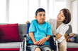 © Art_Photo - Portrait of enjoy happy love family asian mother playing and carer helping look at disabled son child sitting in wheelchair moments good time at home.disability care concept